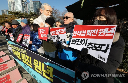 4일 오전 서울 용산구 전쟁기념관 앞에서 열린 '2023년 윤석열 정권 퇴진 규정 촛불대행진 선포식'에서 촛불행동 관계자들이 손팻말을 들고 있다. <연합뉴스>